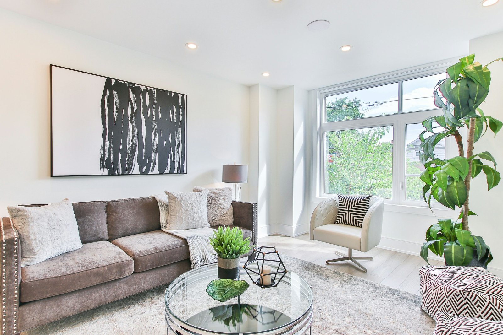 A bright apartment living room with tall windows and hardwood floors